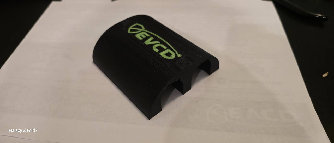 EVCD Arc Duo resting flat on its base with both cable openings on the ground and the green logo facing up
