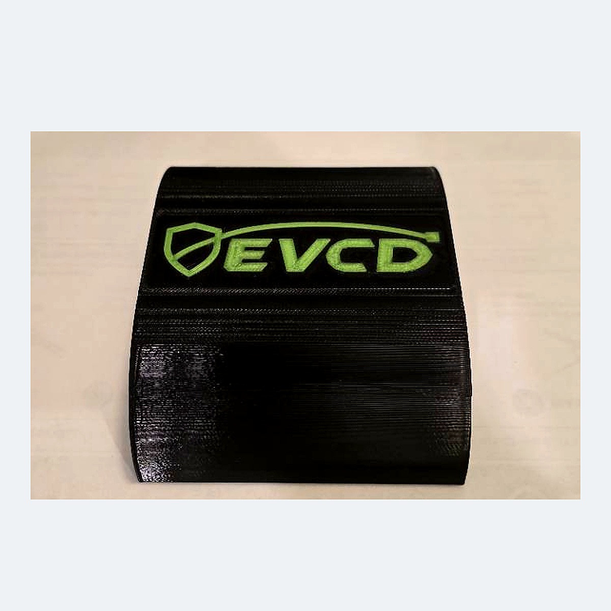Current black PETG EVCD Arc Trio arched cable guard with the green shield-and-cable logo and three channels